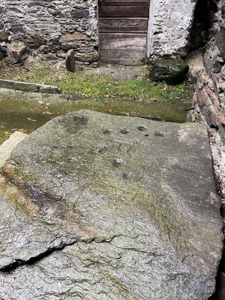Segni di coppelle tra vecchie mura della Valmalenco. Foto Michele Comi