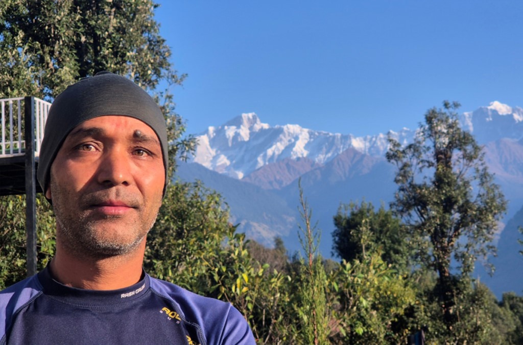 Kundan Singh Bisht e, sullo sfondo, il massiccio del Kedarnath. Foto Stefano Ardito