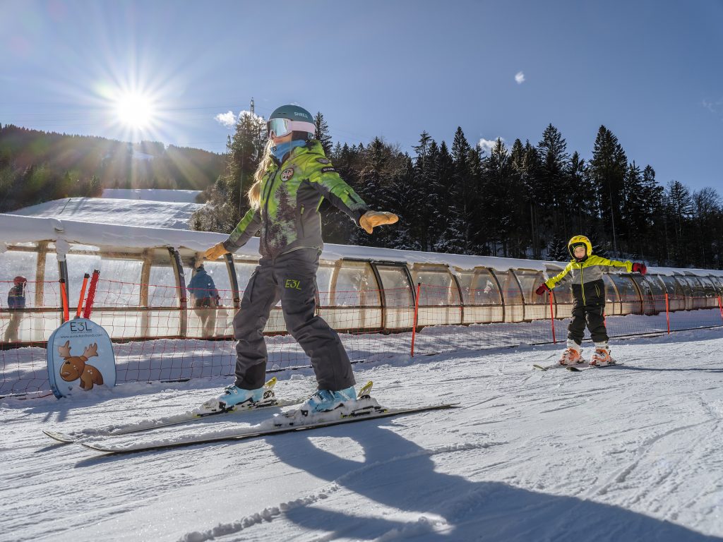 © Luciano Gaudenzio | Giovane maestra con allievo che impara lo
sci alpino in un campo scuola a Tarvisio.
